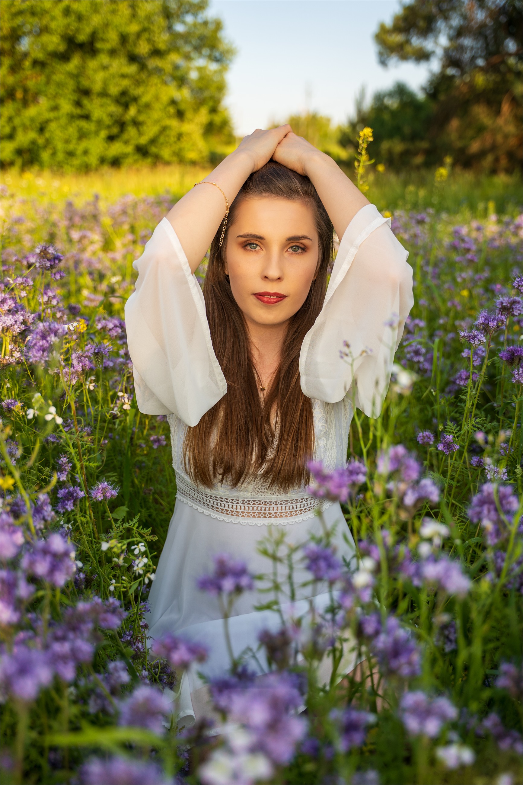 Spokojny portret kobiety wśród fioletowych kwiatów.