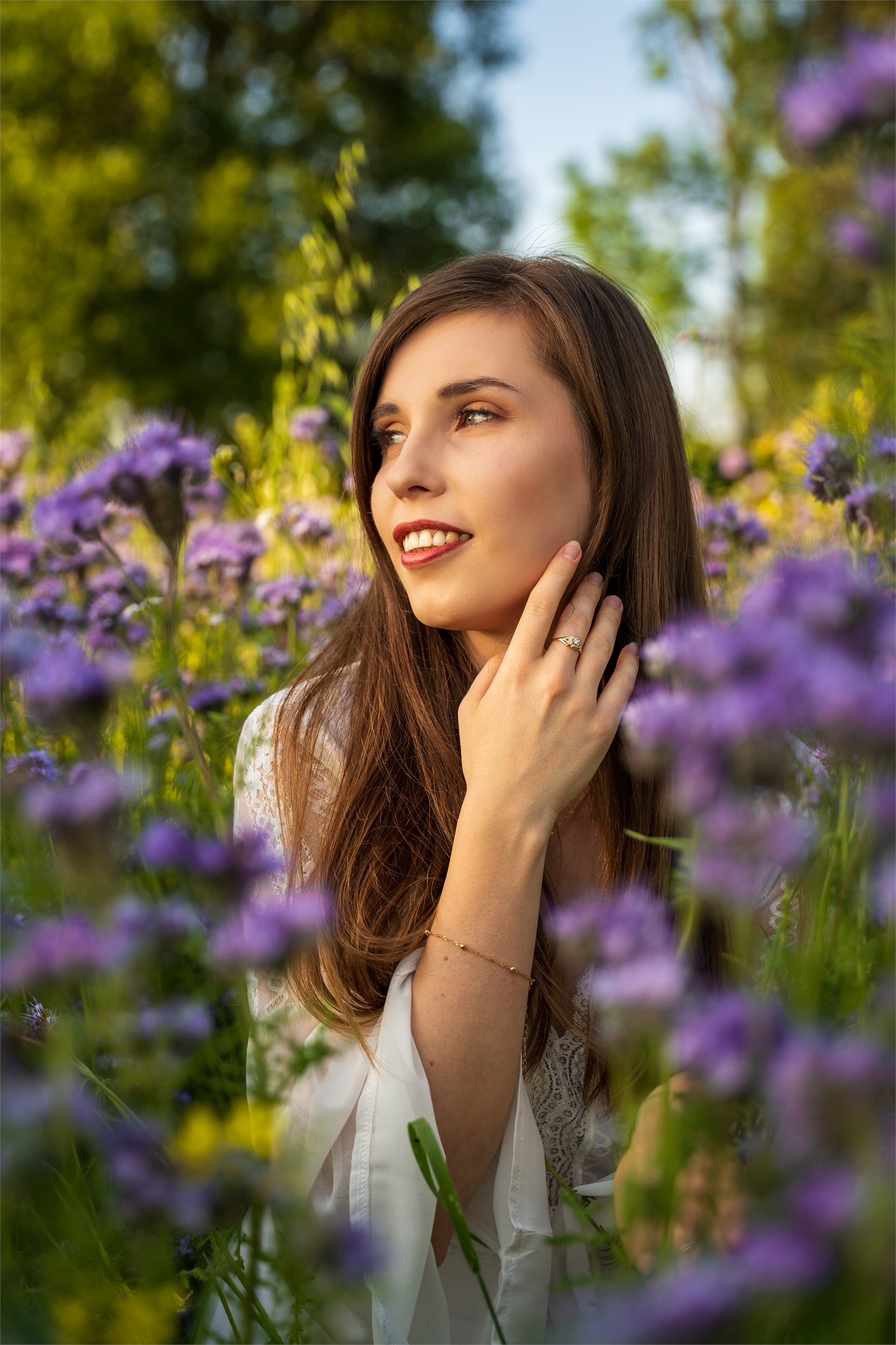 Naturalny portret kobiety wśród fioletowych kwiatów.